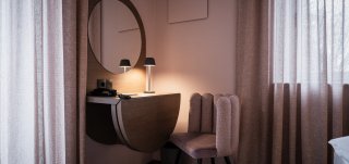 la-villetta_nido-zimmer-10-schreibtisch.jpg Schlafzimmer in La Villetta, Zimmer 10 mit Schminktisch, runden Leuchten, rundem Spiegel, Polstterstuhl und soften Vorhängen, alles in Mauve